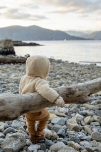 Kind op het strand met teddy jas