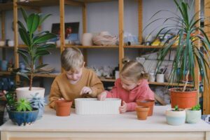 Kinderen planten zaden in bloempotten 1